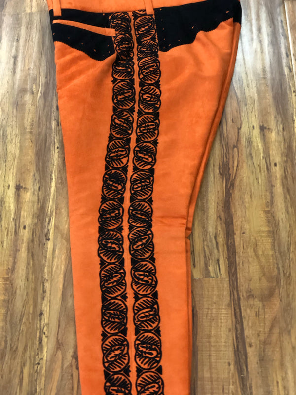 PANTALON DE CHARRO. AUTHENTIC CHARRO PANTS THAT ARE ORANGE WITH MOCA BROWN SUEDE LEATHER STITCHED STENCIL ART WORK